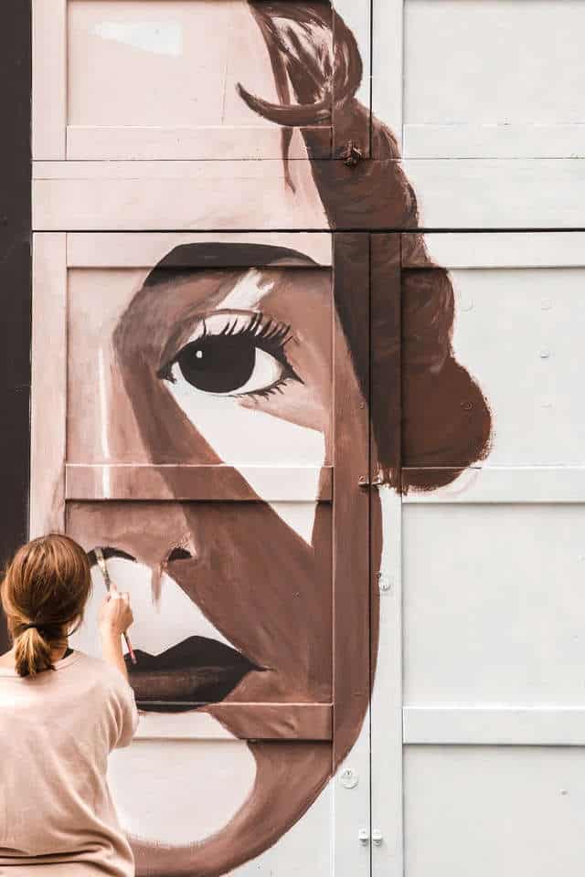 Girl painting a face on building